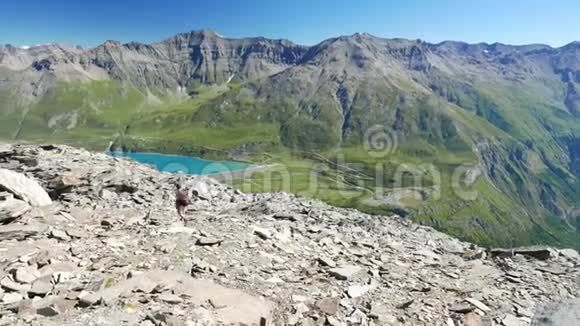 女子行走在高空落基山景观中意大利法国阿尔卑斯山的夏季冒险慢动作视频的预览图