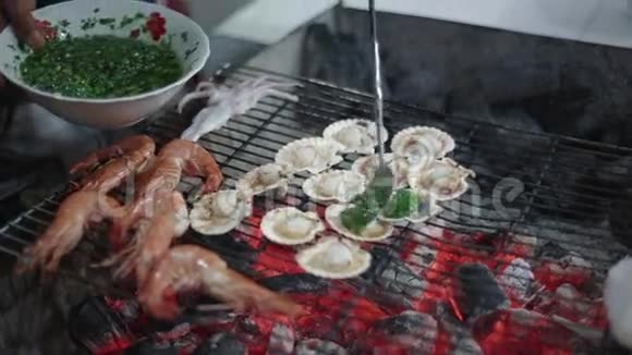 海鲜烧烤虾和扇贝在烤架上美味的摊位食品出售越南视频的预览图