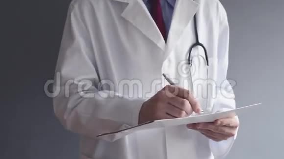 男医生正在站立时写RX处方视频的预览图