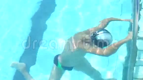 小男孩在透明的蓝色水中潜水视频的预览图