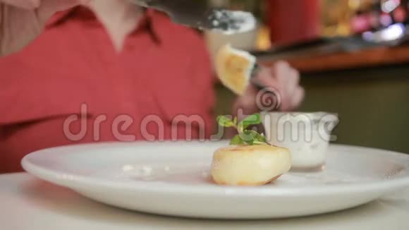 那个在咖啡馆里吃奶酪煎饼的女孩用酸奶油叉和刀视频的预览图