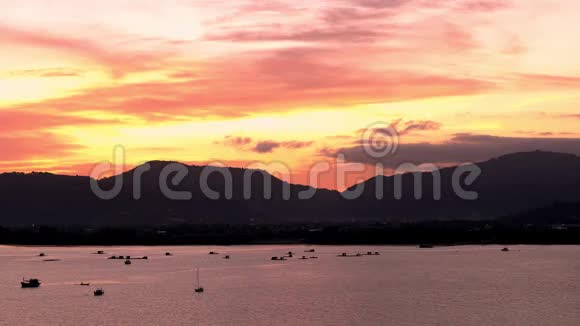 夕阳在海上群山在背景五彩缤纷的天空在海洋的船普吉岛泰国亚洲4K视频的预览图