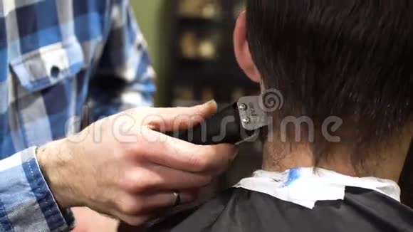 一个留胡子的理发师用梳子和修剪器仔细地给他的客户理发的肖像4K视频的预览图