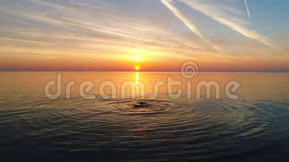 在海水和波浪上俯瞰金色日出的空中景色视频的预览图