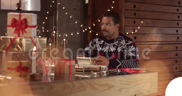 可爱的情侣穿着冬天的毛衣包装圣诞礼物视频的预览图
