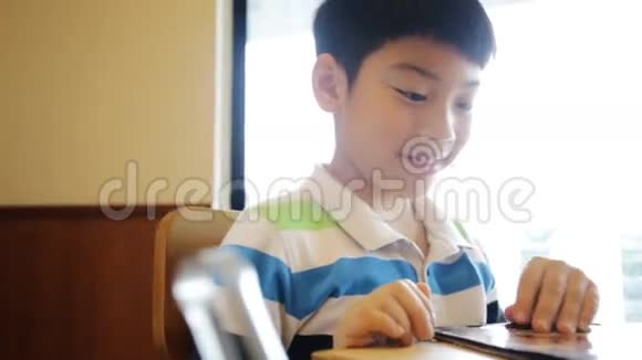 快乐亚洲可爱男孩阅读菜单书和点视频的预览图