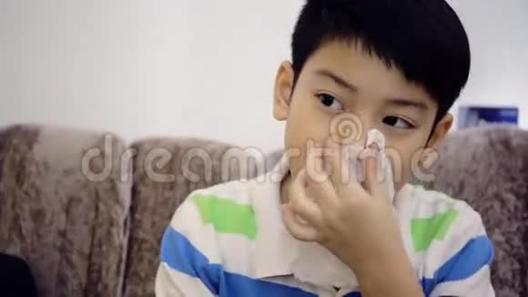 患有流感的亚洲幼儿打喷嚏并用纸巾清洁视频的预览图