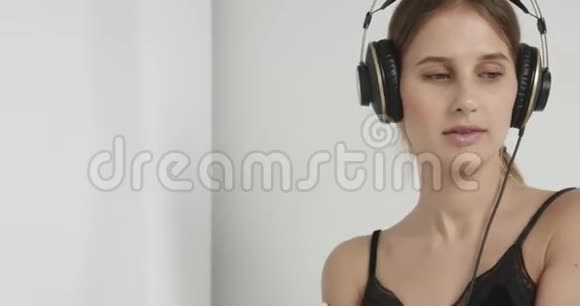 穿内衣的可爱女孩戴着耳机跟音乐跳舞视频的预览图