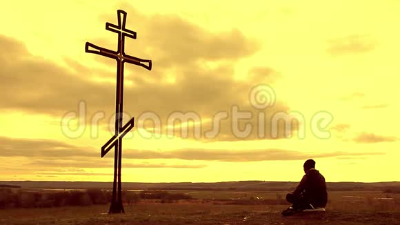 山顶上的剪影人满怀希望地看着基督教十字架一个向十字架忏悔的人视频的预览图
