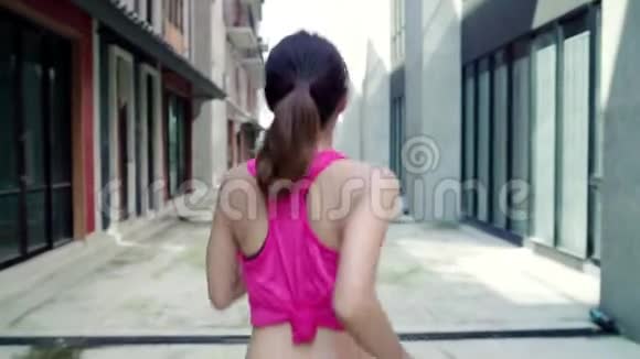 慢动作健康美丽的年轻亚洲跑步女子运动服装跑步和慢跑在城市街头视频的预览图