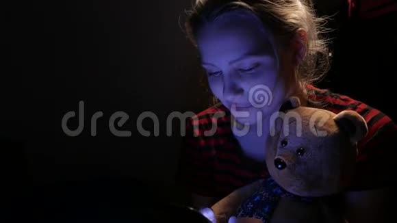 十几岁的女孩在家里和一只玩具熊和一只小狗在电话里聊天4UHDK视频的预览图