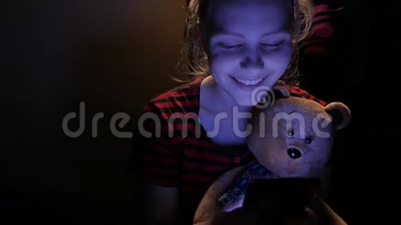 十几岁的女孩在家里和一只玩具熊和一只小狗在电话里聊天4UHDK视频的预览图