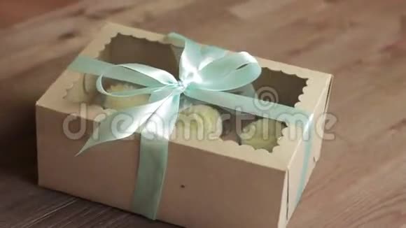 由回收纸箱和丝带制成的礼物在木头背景上旋转视频的预览图