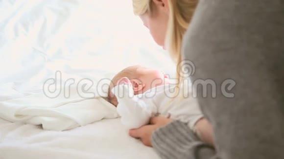 女人和一个躺在床上的婴儿玩耍视频的预览图