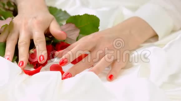 女性的手白色丝绸上有玫瑰视频的预览图