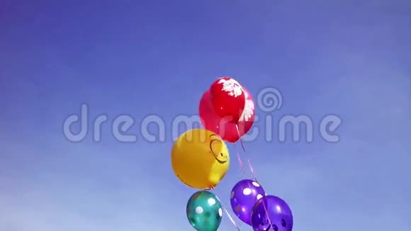 五颜六色的派对气球漂浮在空中迎着明亮的蓝天视频的预览图