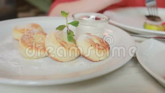 那个在咖啡馆里吃奶酪煎饼的女孩用酸奶油叉和刀视频的预览图