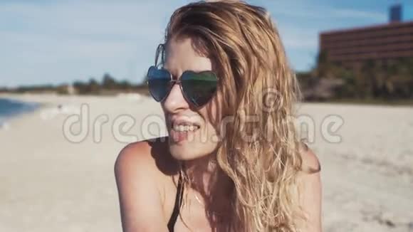 沙滩上戴太阳镜的女孩微笑着视频的预览图