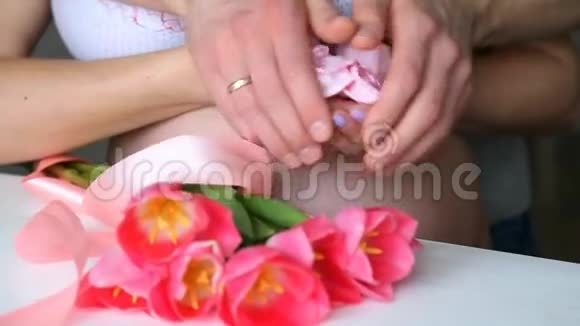 怀孕的夫妇手里拿着粉红色的小袜子孕妇视频的预览图