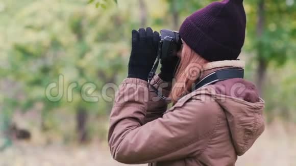 秋日美丽的两人旅游摄影师拍摄森林视频的预览图
