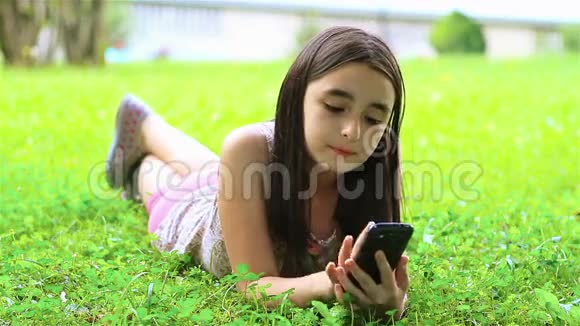 小女孩在智能手机上玩电子游戏视频的预览图