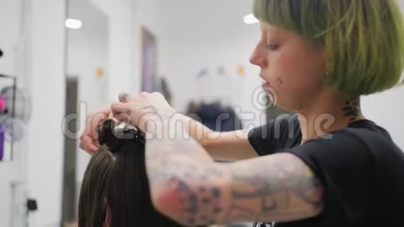 在美容院为女孩做创意发型的专业女性理发师视频的预览图