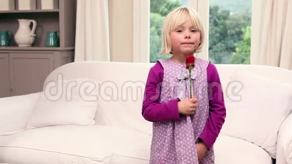 可爱的小女孩捧着一朵红玫瑰视频的预览图