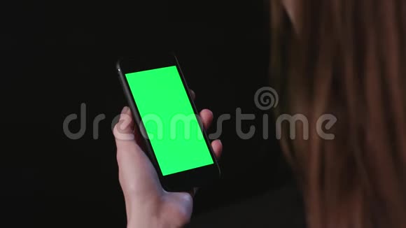 女人拿着绿色屏幕截图的手机视频的预览图