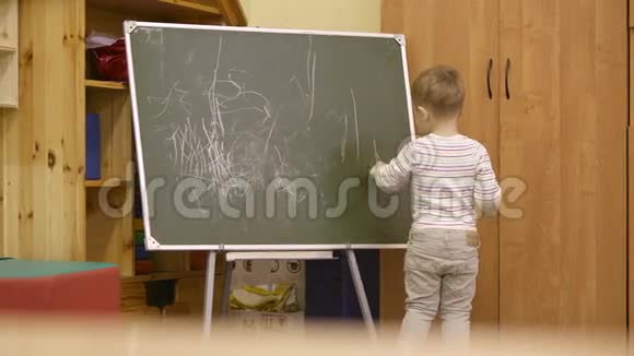 小男孩在幼儿园画黑板视频的预览图