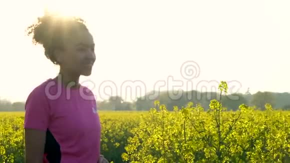 非洲裔美国少女女青年从水瓶中喝水在黄花地跑步或慢跑视频的预览图