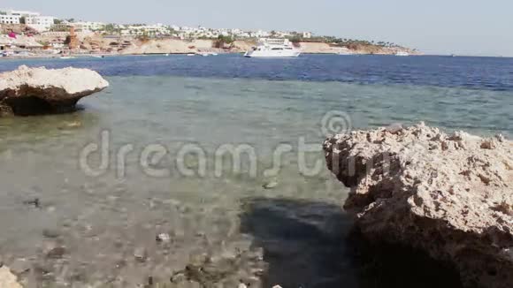 干净的海水和美丽的海岸线和漂浮的白色船只视频的预览图