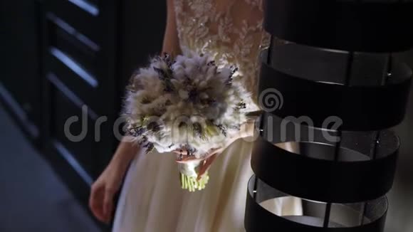 穿着婚纱的年轻新娘在室内捧着花束白色豪华礼服视频的预览图