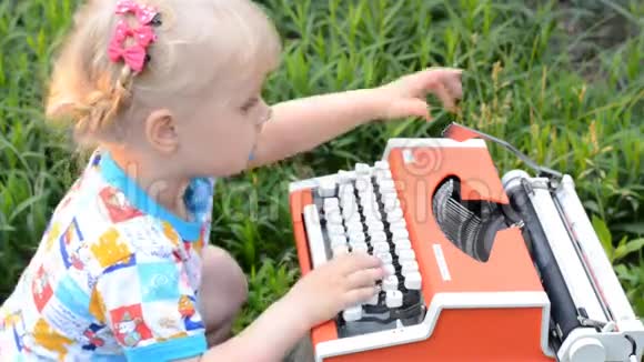 可爱的小女孩在老式打字机上写作视频的预览图