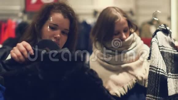 店里有两个年轻的女人在店里挑选温暖的冬装视频的预览图