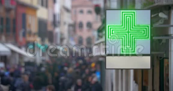 繁忙街道上有绿色十字路口的药房标志视频的预览图