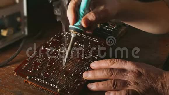 老人修理芯片无线电技师烟来修理烙铁工程师或技师修理视频的预览图