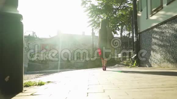 时髦的女人在阳光下缓慢地走在街上视频的预览图