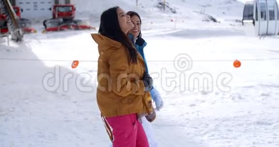 两个年轻的女人在度假村的雪地里散步视频的预览图