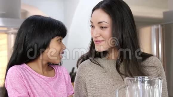 母亲和女儿在厨房里煮水果视频的预览图