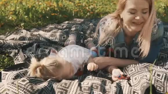 母亲和女儿躺在草坪上户外城市公园的家庭视频的预览图