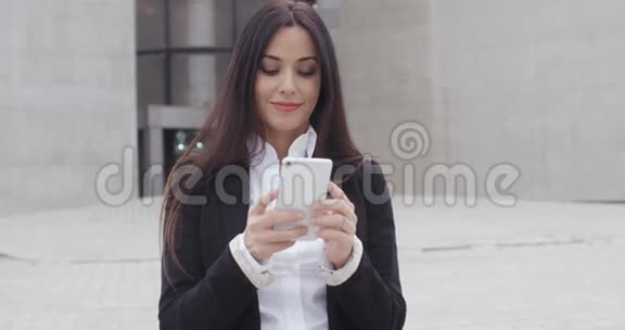 漂亮的女商人检查她的手机视频的预览图