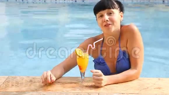 女人在游泳池喝鸡尾酒放松视频的预览图