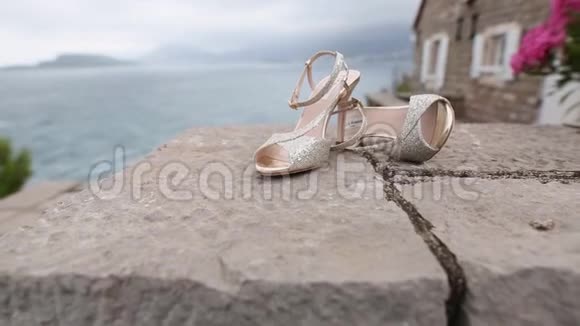 海边岩石上的结婚鞋视频的预览图