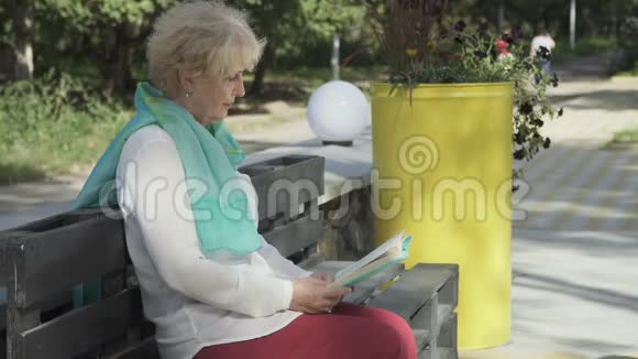 老妇人在公园看书视频的预览图