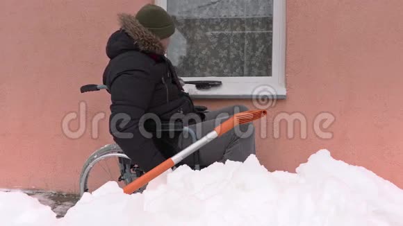 冬天轮椅上清洁窗户的残疾人视频的预览图