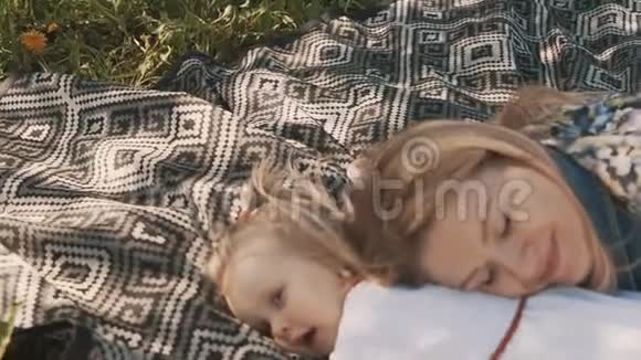 母亲和女儿躺在草坪上母亲和童年的幸福视频的预览图