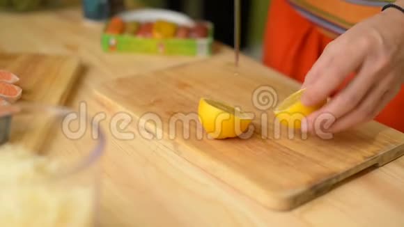 女孩在木切割板上切柠檬片视频的预览图