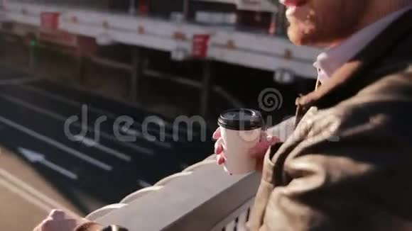 男人看着城市里的交通喝着咖啡视频的预览图