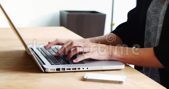 坐在办公桌前使用笔记本电脑的女性高管视频的预览图