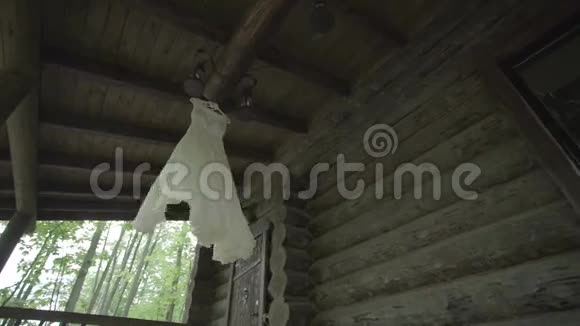 白色婚纱挂在木屋上视频的预览图